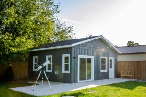 a gray shed with a telescope in front of it at Blue Moon Bungalow in Tillsonburg