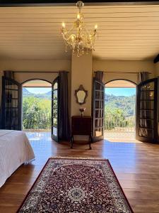 a bedroom with a bed and a chandelier at Pousada Casa Florinda in Teresópolis