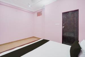 a bedroom with a bed with a door in it at Hotel O Relax Inn in Lucknow +21 photos