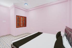 a white room with a bed and a window at Hotel O Relax Inn in Lucknow