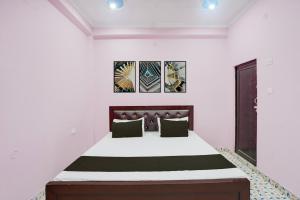 a bedroom with a bed with white walls at Hotel O Relax Inn in Lucknow