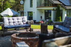 a patio with two couches and a fire pit at Willa Vivaldi - Family & Friends - Sauna, Balia in Grzybowo
