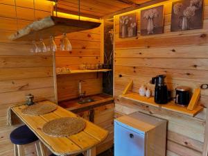 a wooden cabin with a wooden table and a kitchen at YAYLAMİSUN SUITE HOTEL Luxury Nature Stay Çamlıhemşin in Çamlıhemşin