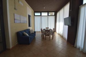 a living room with a blue couch and a table at Loredana's House in Pachino