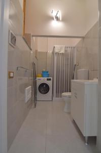 a bathroom with a toilet and a washing machine in it at Loredana's House in Pachino +17 photos
