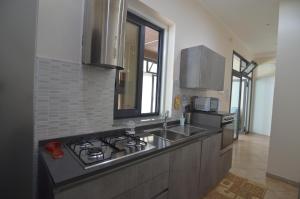 a kitchen with a sink and a stove at Loredana's House in Pachino