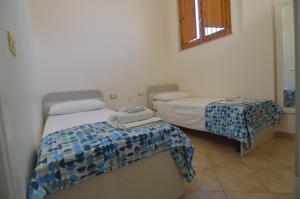 a bedroom with two beds and a table with towels at Loredana's House in Pachino