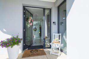a hallway with a door and a chair and flowers at Willa Vivaldi - Family & Friends - Sauna, Balia in Grzybowo