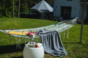 a hammock with a blanket on it in a yard at Willa Vivaldi - Family & Friends - Sauna, Balia in Grzybowo +73 photos