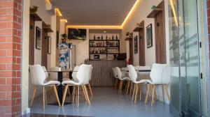 a restaurant with white chairs and a table and a bar at HOTEL LIBERTAS in Vlorë