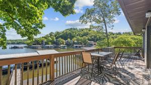 a balcony with a table and chairs and a view of a river at Honey Hole 3 Well Dock in Camdenton