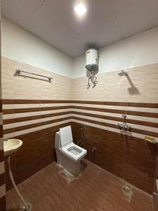 a bathroom with a toilet and a sink at Aanadam Resort in Jaipur