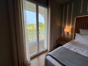 a bedroom with a bed and a sliding glass door at ViLLA HELENA - anciennement LE CLOS D'IGNAC in Lège-Cap-Ferret +71 photos