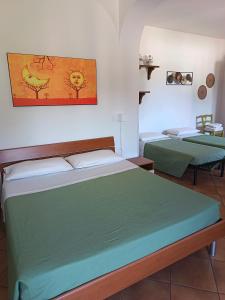 a bedroom with two beds and a painting on the wall at Contrada Macchia B&B in Tricase +51 photos