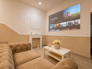 a living room with a couch and a tv on the wall at Eaux Spa Rive Droite in Rouen