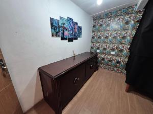 a room with a wooden cabinet and paintings on the wall at Nomad Hostel - Vila Madalena in São Paulo +29 photos