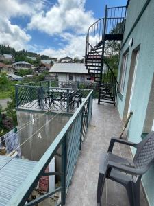 a balcony with a chair and stairs on a house at Bakuriani Mtis 6 in Bakuriani