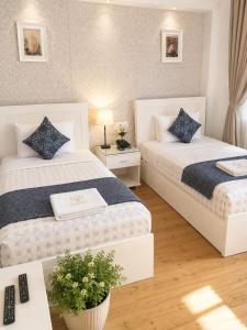 a bedroom with two beds and a table with a plant at new colmbia in Cairo +4 photos