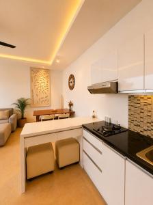 a kitchen with white cabinets and a living room at Asania Villa in Uluwatu