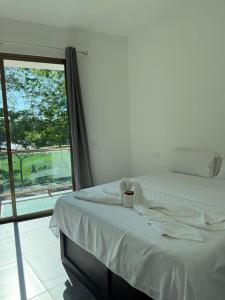 a bedroom with a bed and a large window at Hotel Kleos in Cárdenas