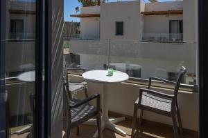 a balcony with two chairs and a table and a table at Nikolas Apartments in Amoudara Herakliou