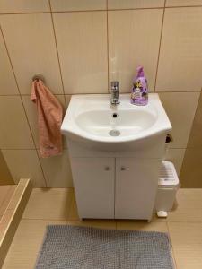 a bathroom with a white sink with a purple bag on it at Purple Madame in Balatonszárszó +3 photos