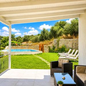a patio with a view of a yard with a swimming pool at Endless Green Villa in Argostoli