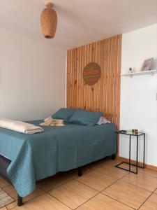 a bedroom with a blue bed with a wooden wall at La Terraza Orgánica in Cartago