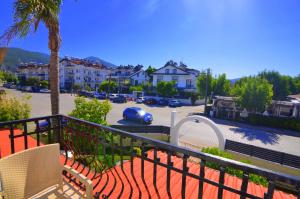a balcony with two chairs and a parking lot at Fethiye Cagri Pansiyon in Fethiye