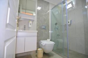a bathroom with a toilet and a glass shower at Fethiye Cagri Pansiyon in Fethiye