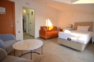 a bedroom with a bed and a couch and a table at Fethiye Cagri Pansiyon in Fethiye