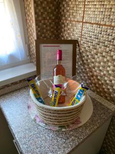 a basket with a bottle of alcohol and two toothbrushes at Purple Madame in Balatonszárszó