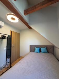 a bedroom with a bed with blue pillows at Poilsis Urbo Nidoje in Nida