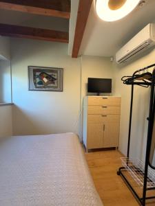 a bedroom with a bed and a tv and a dresser at Poilsis Urbo Nidoje in Nida +12 photos