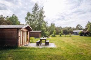 a picnic table and benches in a yard at Šķilas in Pērkone +19 photos