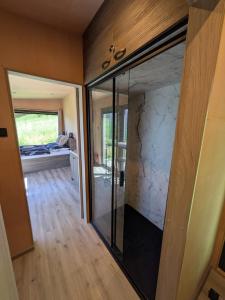 a room with a glass door leading to a bedroom at Tiny House Dedinky in Dedinky