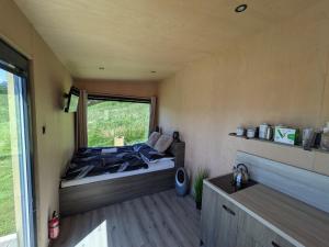 a bed in a small room with a window at Tiny House Dedinky in Dedinky +8 photos