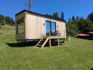 a tiny house sitting on top of a field at Tiny House Dedinky in Dedinky