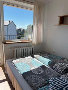 a bedroom with a bed in front of a window at Willa Lazur in Władysławowo