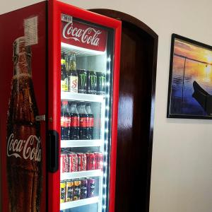 an open coca cola refrigerator filled with drinks at Hotel Mazzuco in Araranguá