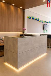 an office lobby with a reception counter with lights at Hotel Mazzuco in Araranguá
