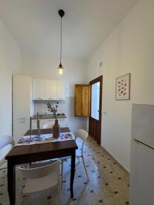 a kitchen with a table and chairs in a room at La casa di GiòGiò in San Vito lo Capo