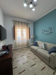 a living room with a couch and a window at La casa di GiòGiò in San Vito lo Capo