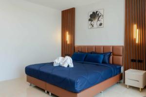 a bedroom with a blue bed with a wooden headboard at PGD brown city view in Rawai Beach