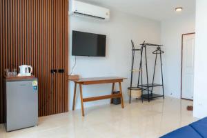 a room with a refrigerator and a table and a tv at PGD brown city view in Rawai Beach