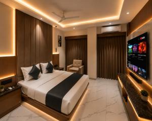a bedroom with a bed and a flat screen tv at Hotel The Sun B&B in New Delhi