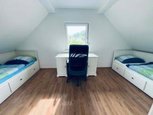 a bedroom with two beds and a desk and a chair at M&M house in Bizeljsko +8 photos