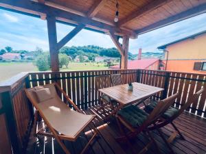 a wooden table and chairs on a deck at M&M house in Bizeljsko