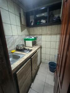 a small kitchen with a sink and a microwave at Résidence New Land Sarl in Douala