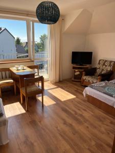 a room with a bed and a table and a television at Willa Lazur in Władysławowo